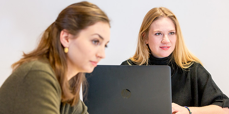 Two female students in front of laptop